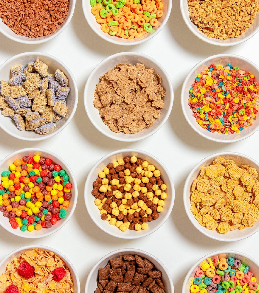 bowls of a variety of dry cereals on white background