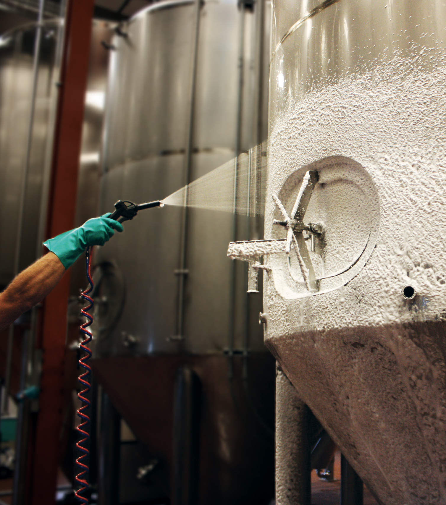 employee spraying foam product in beverage facility