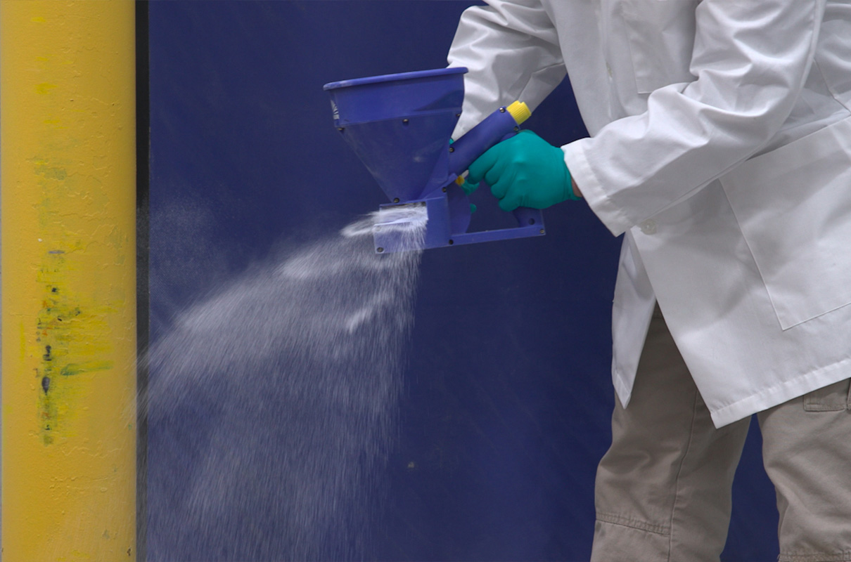 man using hand dispensing tool to dispense sterilex powder