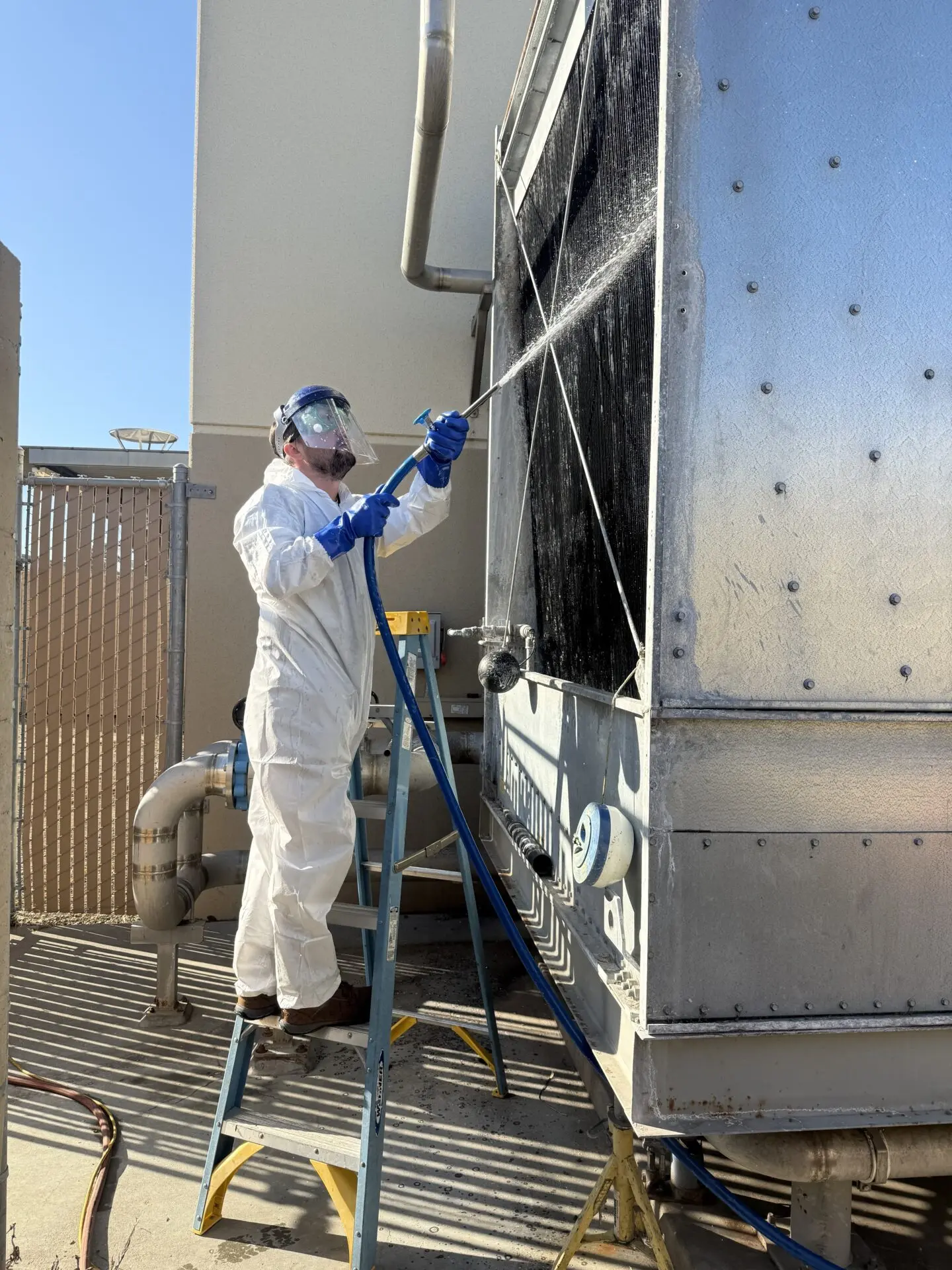 Employee spraying cool cells equipment